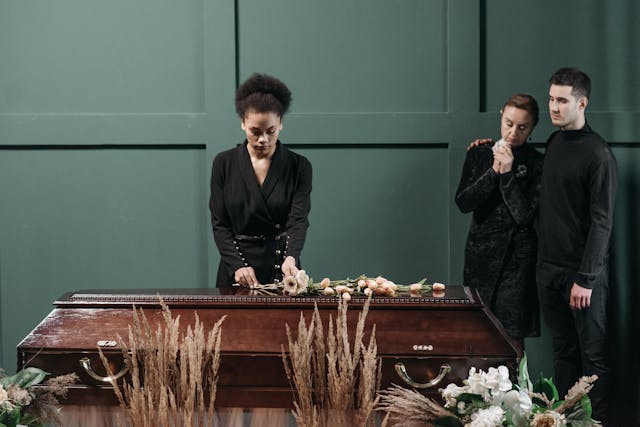 people surrounding coffin at wake